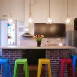 Fully equipped shared kitchen featuring a breakfast bar and colorful seating at Choco Hostel in Cluj.