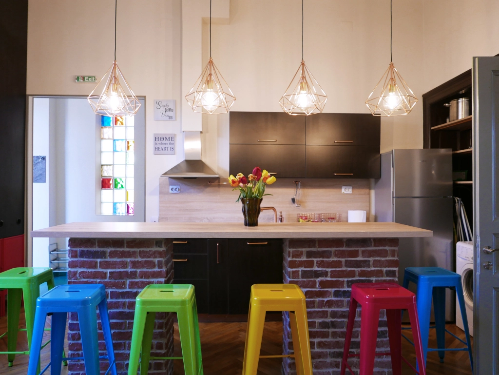 Fully equipped shared kitchen featuring a breakfast bar and colorful seating at Choco Hostel in Cluj.