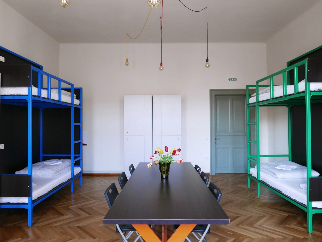 Comfortable bunk beds and spacious group seating area in the shared dorm room at Choco Hostel.