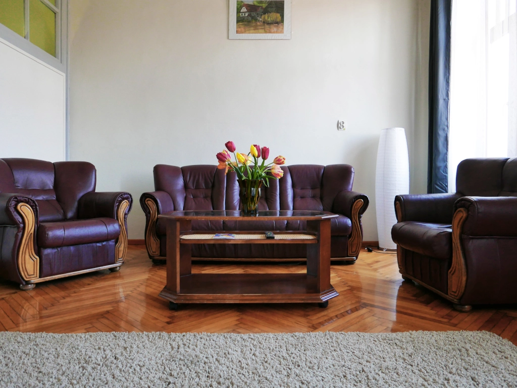 Comfortable suite living room featuring leather sofas, hardwood floors, and a relaxing seating area.