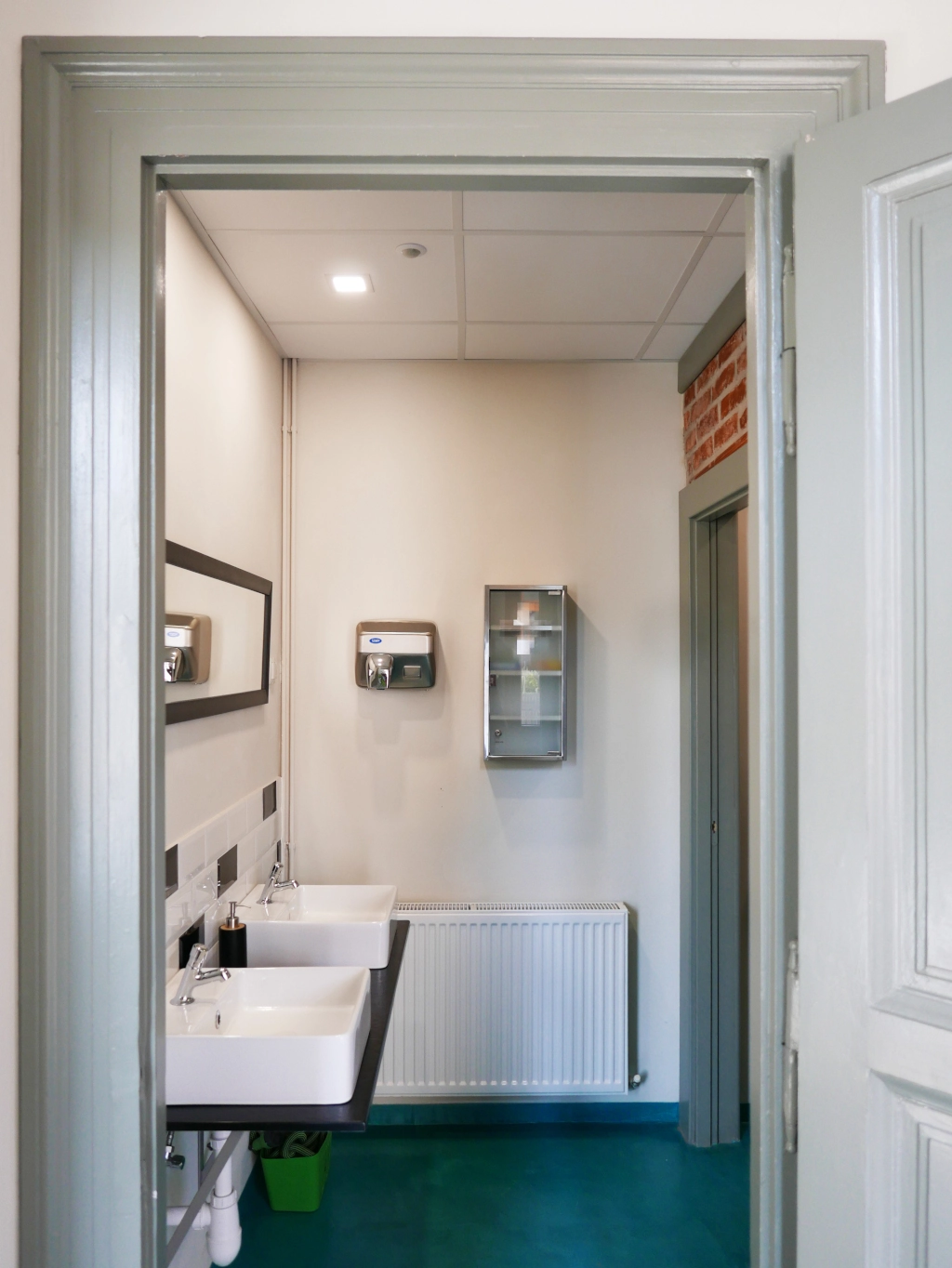 Clean, modern shared bathroom facilities with multiple sinks and large mirrors for guest use.